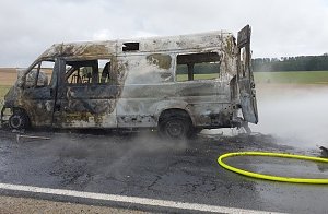 Das ausgebrannte Wohnmobil muss weiter gel&ouml;scht werden, um weiteres Entflammen zu verhindern.