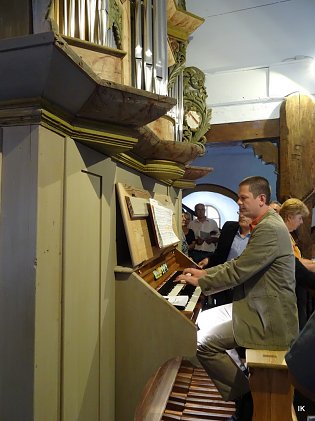 Bild: Oliver Stechbart an der restaurierten Orgel