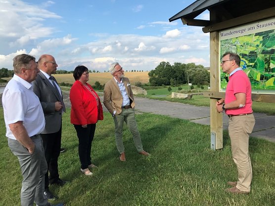 Vor Ort am Stausee - v.li- Ortsb&uuml;rgermeister Dirk Moll, B&uuml;rgermeister Marko Grosa, Christina Tasch (MdL) und Minister Hoff. Roland Senft vom Bauamt stellt LGS-Ma&szlig;nahmen vor. (Foto: Ilka K&uuml;hn)