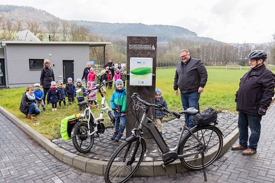 v.r.n.l.: Herbert Richwein und Martin Kozber, B&uuml;rgermeister der Gemeinde Geismar, nahmen zusammen mit dem &ouml;rtlichen Kindergarten die erste E-Bike-Lades&auml;ule in Geismar in Betrieb. (Foto: Eichsfeldwerke GmbH)
