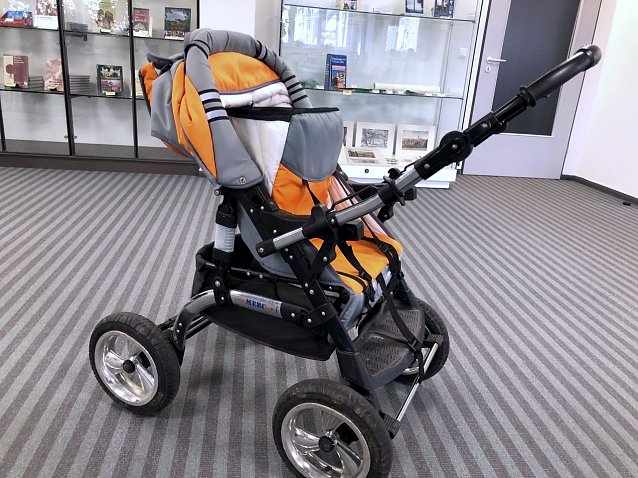 Bild: Der Kinderwagen f&auml;llt besonders durch seine orangefarbenen Stoffbez&uuml;ge auf