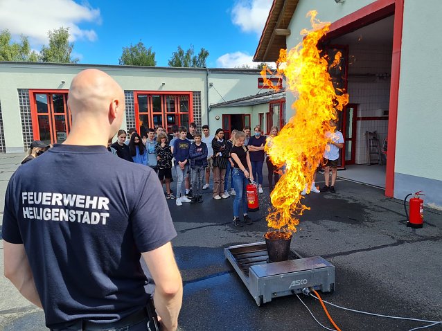 Bild: Sch&uuml;lerinnen und Sch&uuml;ler spielen mit dem Feuer - unter professioneller Aufsicht
