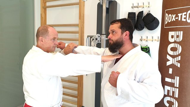 Bild: Foto: l. n. r.: Joachim Retzek und Markus Retzek. Fingerstich (Nukite) zum Kehlkopf = eine Atemitechnik (Sto&szlig;/Schlag) aus dem Karate und die auch innerhalb der Selbstverteidigung im h&ouml;heren Kyu-Bereich (h&ouml;here Sch&uuml;lergruppe) trainiert wird.