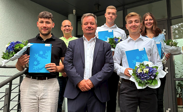 Bild: Niclas B&ouml;hning, Marius Kromer, Simon Egert und Sarah Apostel (v.l.n.r.) mit ihren Abschlusszeugnissen. Gratulationen gab es von B&uuml;rgermeister Christian Zwingmann (Mitte) und Personalrat Kamillo Schwanengel (hinten links). 