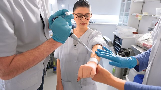 Bild: Schutz&shy;film: Das Pr&uuml;f&shy;team tr&auml;gt eines der Produkte auf den gereinigten Unter&shy;arm der Probandin auf - exakt dosiert und systematisch.