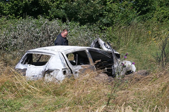 Polizisten untersuchen das ausgebrannte Wrack eines Dacias an der Unglücksstelle (Foto: S.Dietzel) Polizisten untersuchen das ausgebrannte Wrack eines Dacias an der Unglücksstelle (Foto: S.Dietzel)